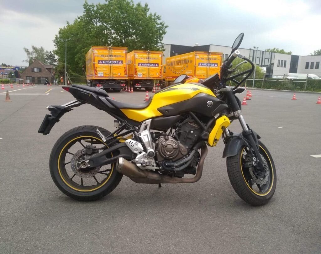 Gelbes Motorrad der Klasse A auf einem Fahrschul-Übungsplatz mit Pylonen